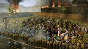 Total War: SHOGUN 2 - Fall of the Samurai - Here we see a large siege battle. The defences have been softened by cannon fire, and the attacking troops are mounting an assault.